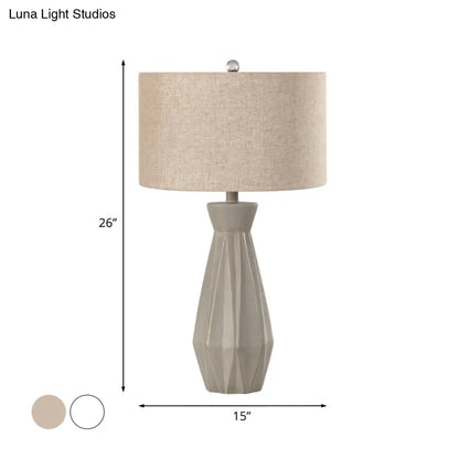 Lámpara de mesa de noche rústica beige/blanca con pantalla cilíndrica de tela.