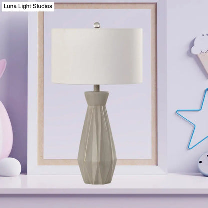 Lámpara de mesa de noche rústica beige/blanca con pantalla cilíndrica de tela.