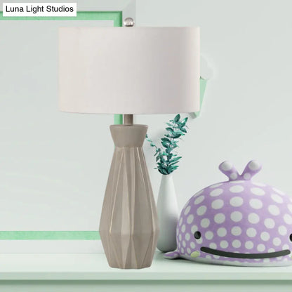 Lámpara de mesa de noche rústica beige/blanca con pantalla cilíndrica de tela.