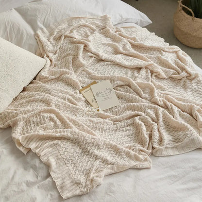Cream-colored knitted bamboo throw blanket with textured cable knit pattern for decorbites cool summer air conditioning use