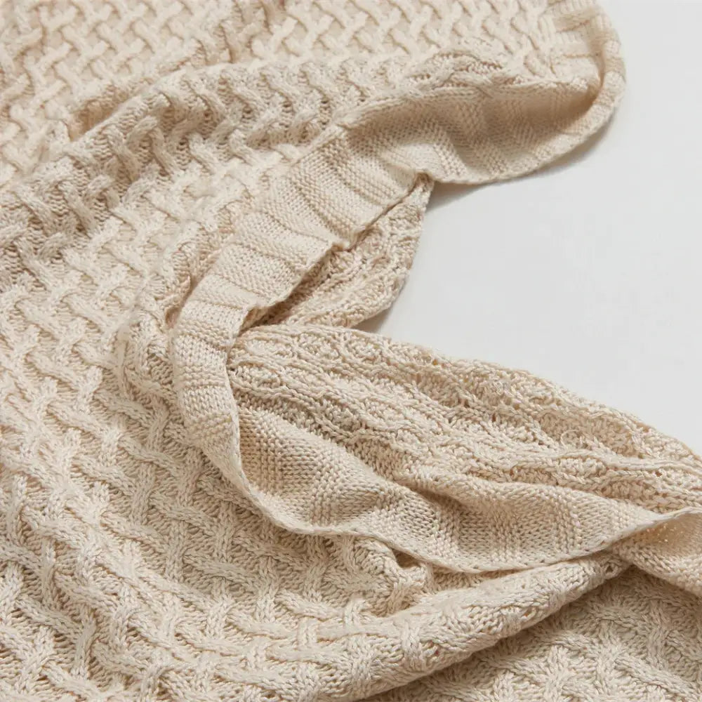 Cream-colored knitted bamboo sweater with textured cable-knit and ribbed edges for decorbites cool summer air use