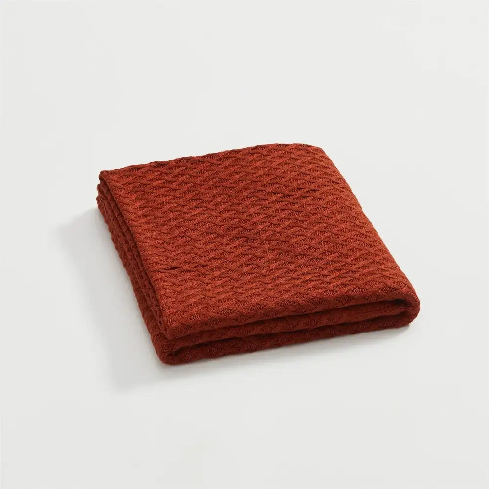A folded terracotta woven bamboo towel with waffle-knit texture for decorbites cool summer air conditioning use