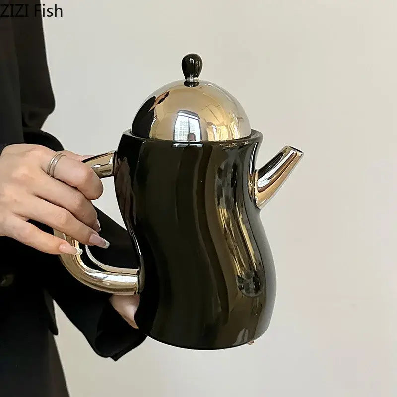 Black ceramic teapot with shiny gold lid handle and spout from decorbites bending design ceramic coffee set