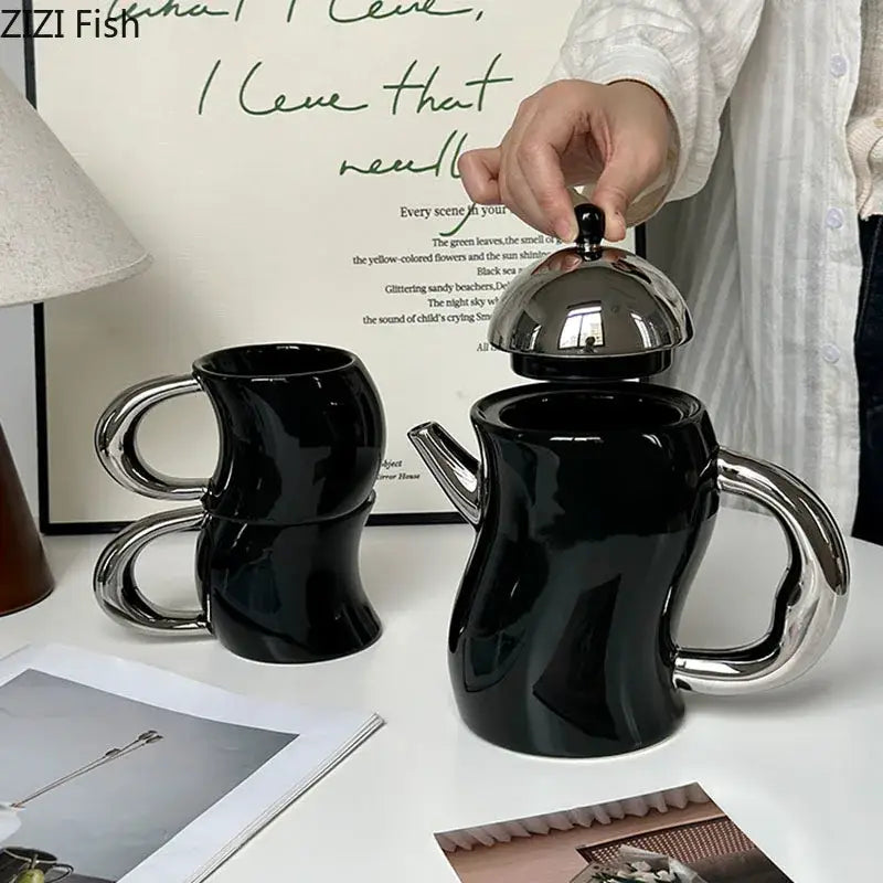 Black ceramic teapot with shiny silver lid and handle featuring abstract sculptural design for decorbites bending design ceramic set