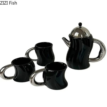 Black ceramic teapot with silver lid and handle and three matching bending design ceramic coffee mugs with chrome handles