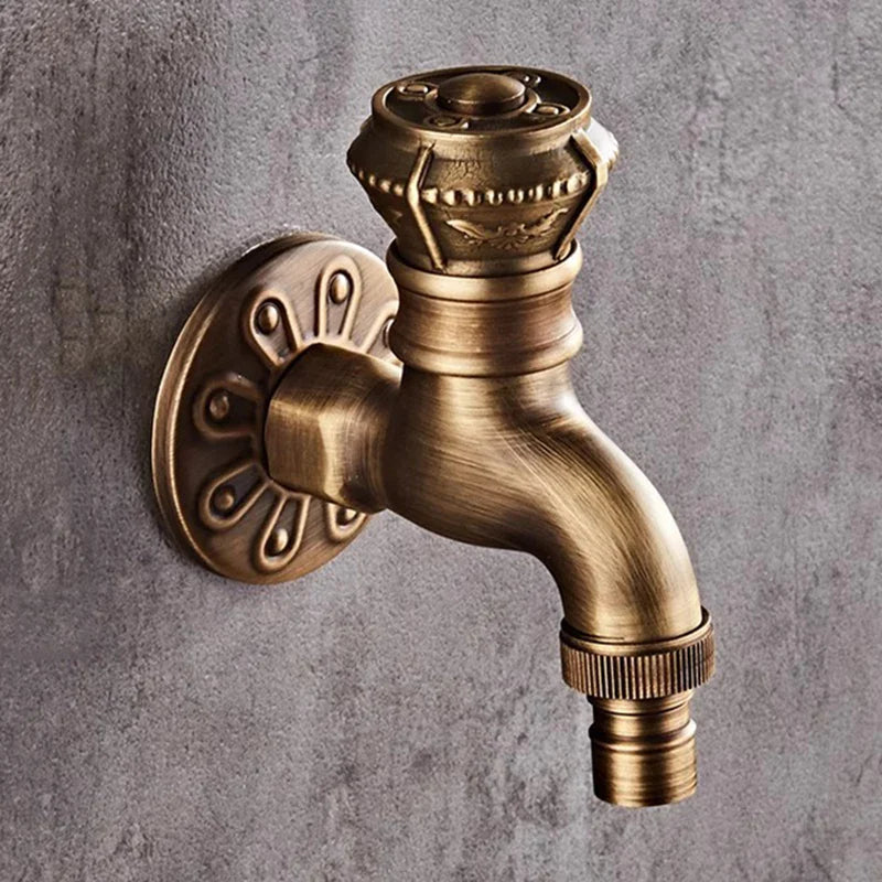 Antique brass-finished wall mounted outdoor bibcock tap with decorative circular handle for garden and kitchen use