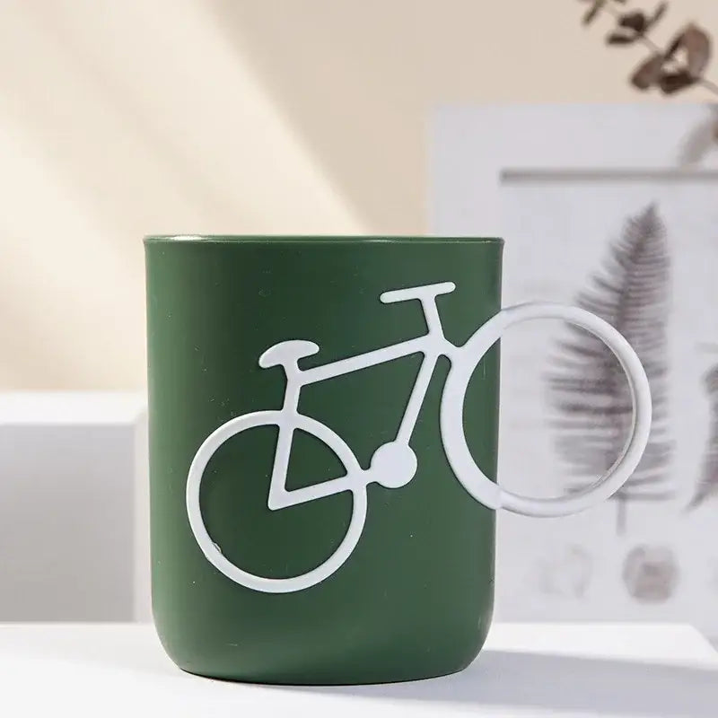 Green ceramic toothbrush holder cup featuring a white bicycle silhouette design for bathroom use