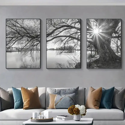 Three black and white framed canvas prints of tree lake sunset branches over water on a gray wall by decorbites