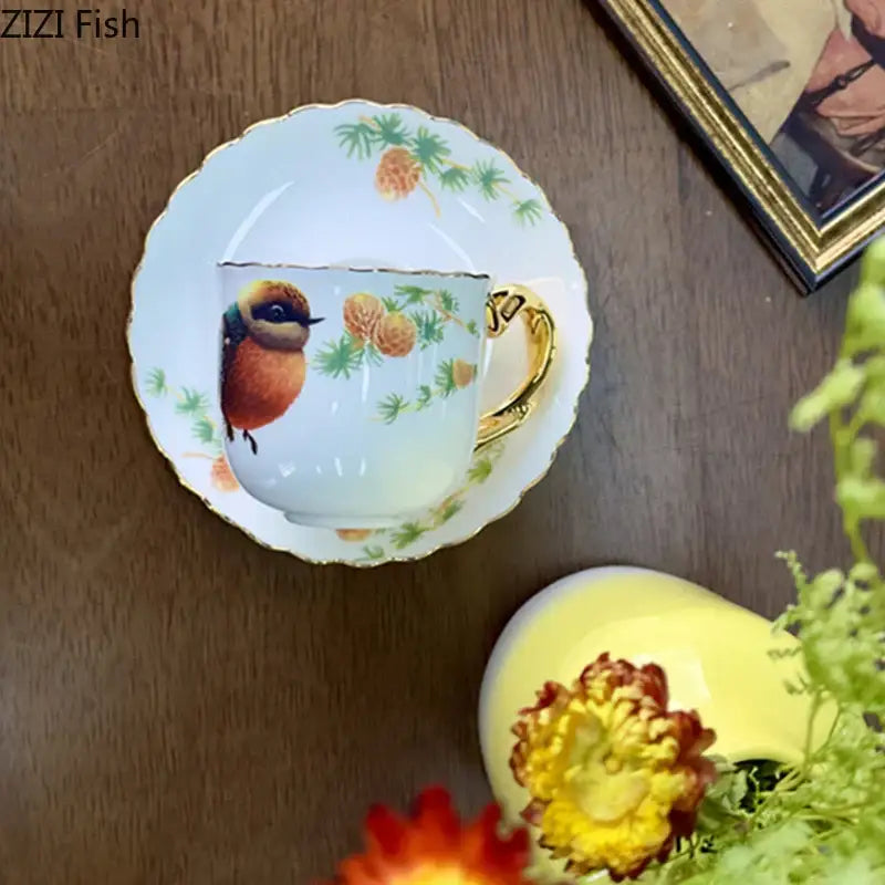 A delicate white porcelain bird pattern ceramic gold trimmed mug with orange-brown bird and pine decorbites bird pattern