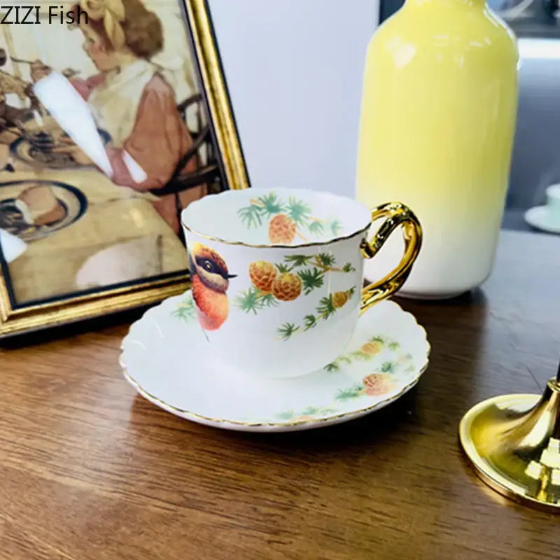 A delicate white porcelain bird pattern ceramic mug with gold trim and colorful pinecone illustration by decorbites bird