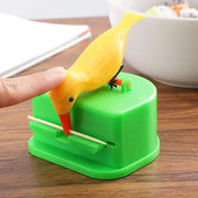 Yellow plastic birdie toothpick holder with orange beak and black feet mounted on a green base decorbites toothpick holder