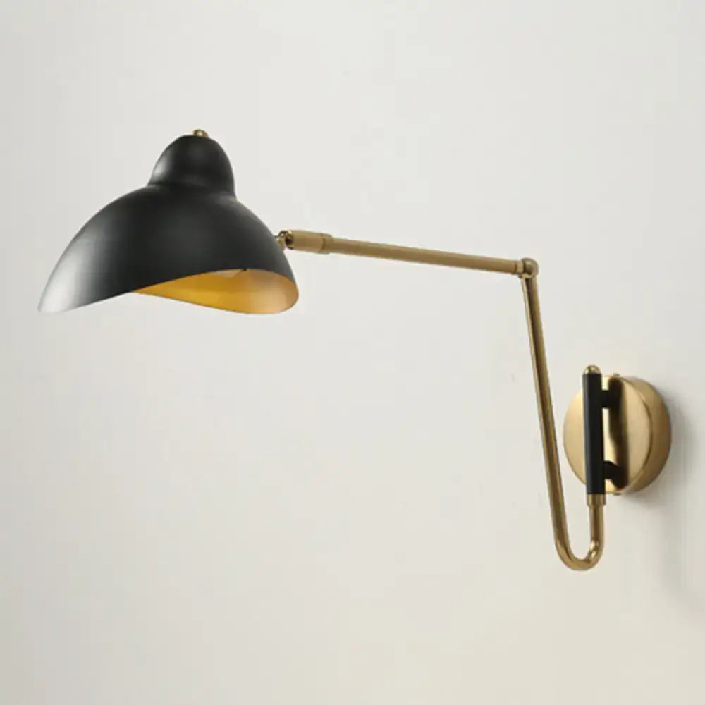 Black and brass duckbill reading light wall lamp with adjustable joint and matte black shade with gold interior