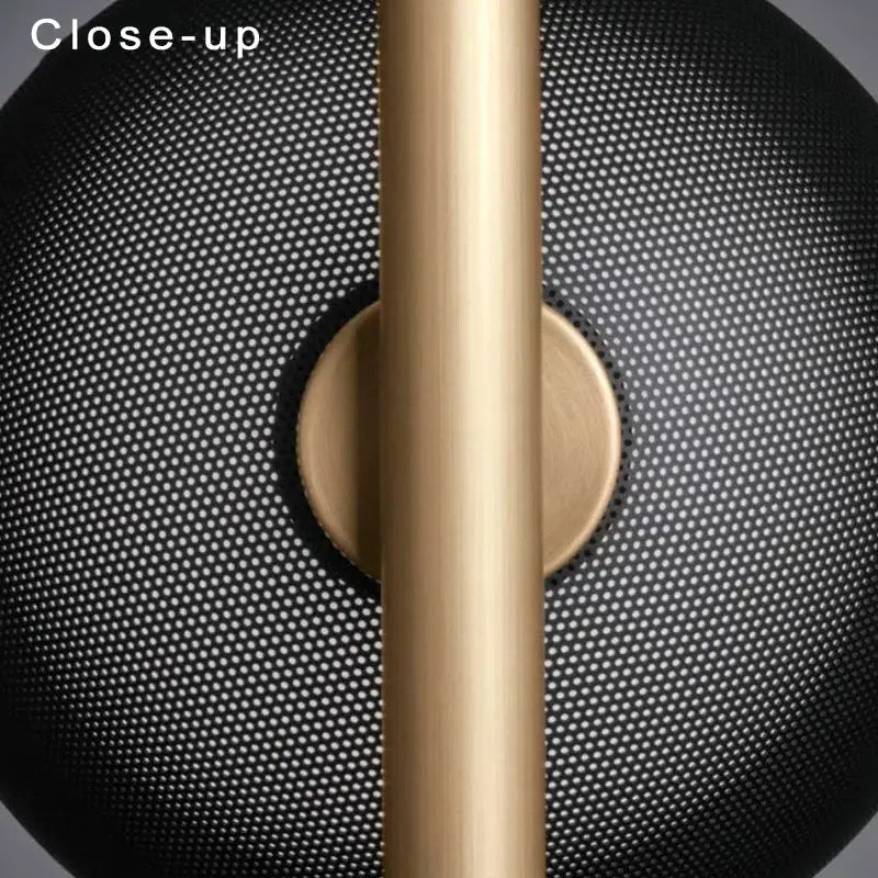 Gold-toned wall lamp with black metal arm and perforated black mesh shade for luxury bedroom decorbites black metal fixture