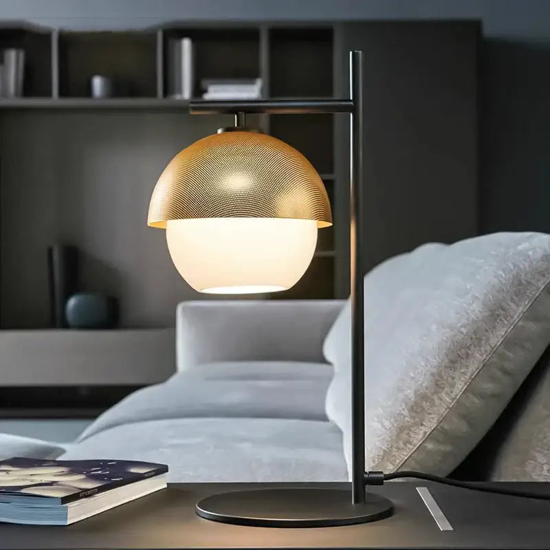 Black and brass mesh globe wall lamp with frosted glass base on a decorbites black metal arm for luxury bedroom decor