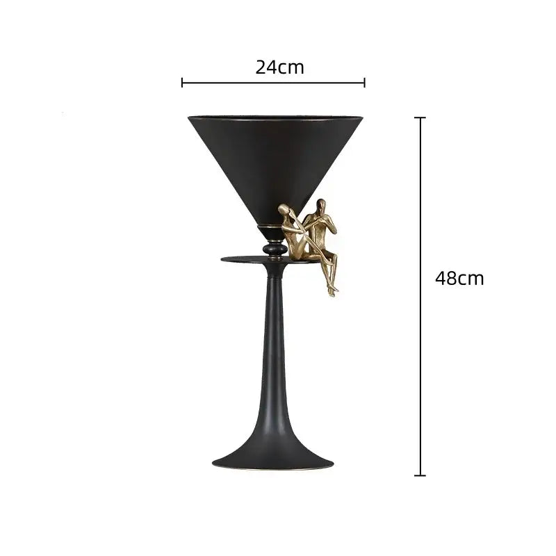 Black and gold decorbites bronze flower vase featuring a bronze martini glass sculpture with gold figurines