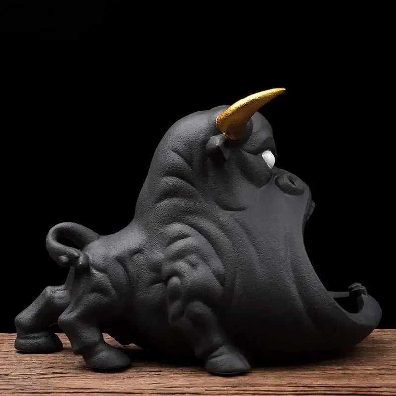 Black and gold ceramic ashtray in the shape of a cartoon cow bull with a golden horn and white eye decorbites cartoon cow