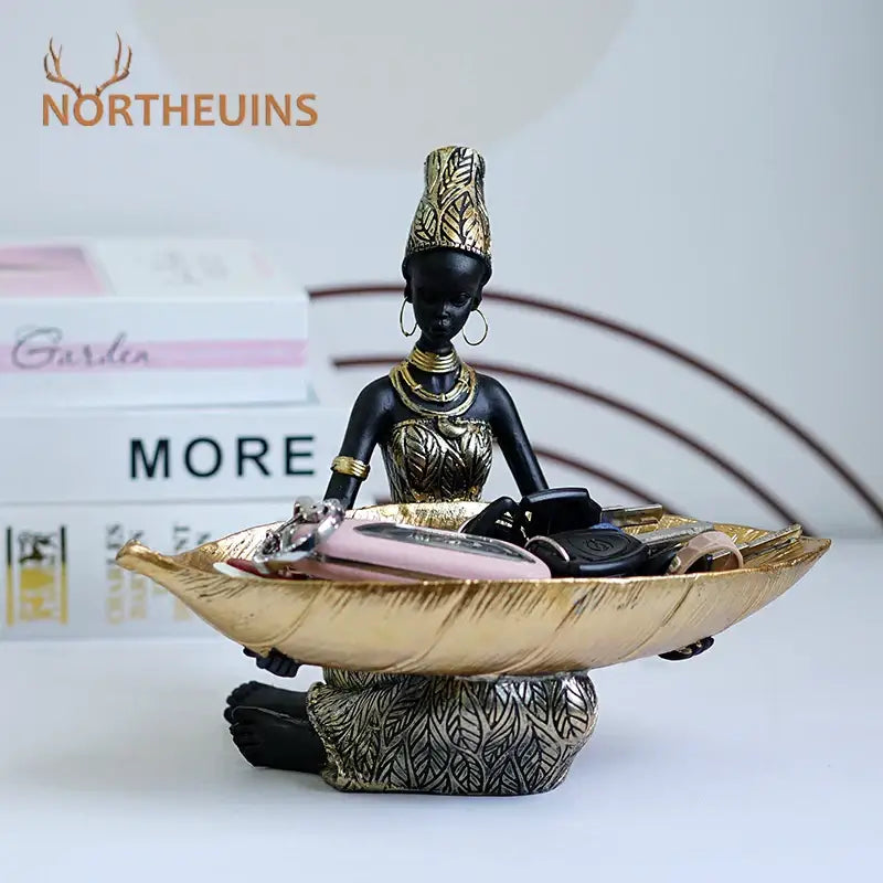 Black and gold resin black woman figurine holding a leaf-shaped tray ideal for living room decorbites black woman decor