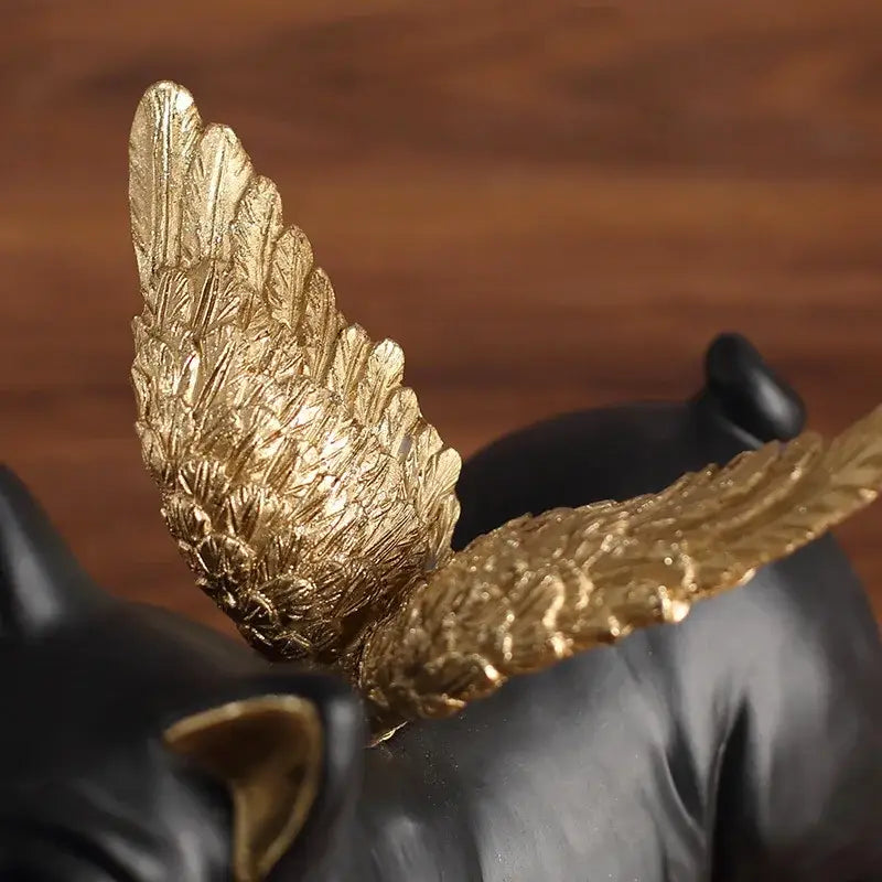 Glossy black french bulldog dog sculpture with golden metallic detailed wings shown from the back for living room decor