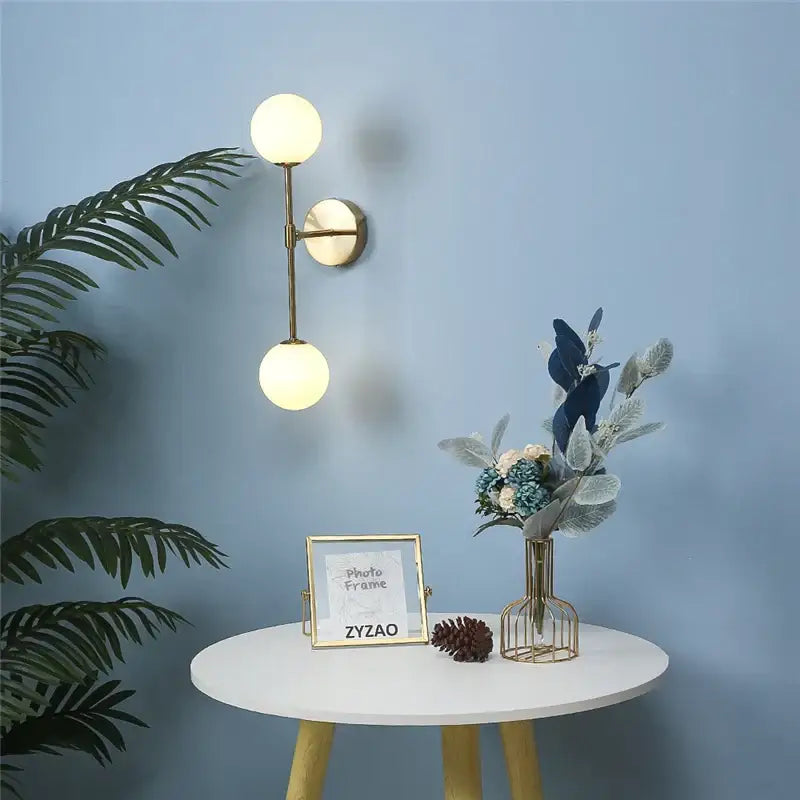 Gold-toned double globe wall lamp with frosted glass shades decorbites golden glass led bedroom sconce design