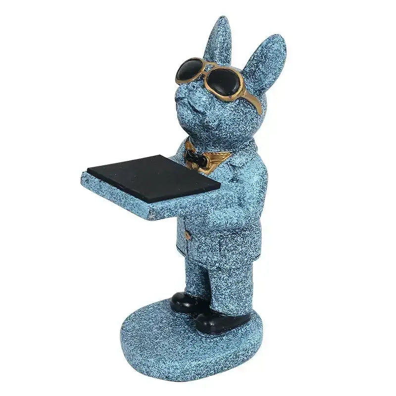 Blue glittery rabbit figurine with gold-rimmed sunglasses holding a tray beside a black and purple cartoon bear watch stand