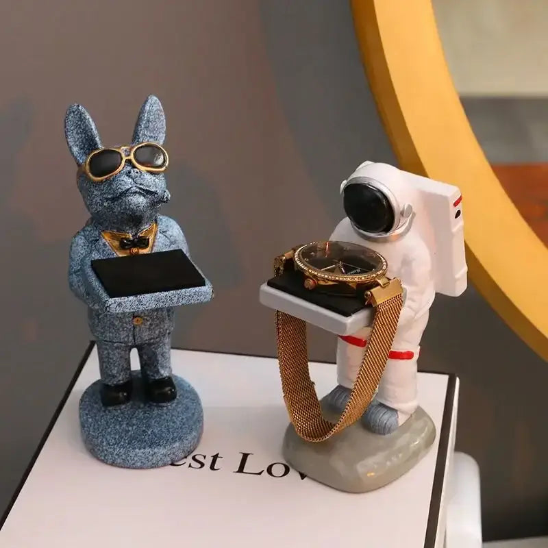 Blue glittery rabbit figurine wearing gold-rimmed sunglasses and bow tie holding tray beside cartoon bear watch stand decor