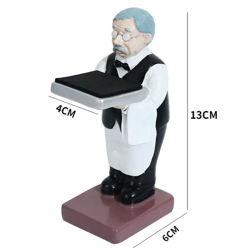 A 13cm resin figurine of a vintage waiter with light blue hair holding a tray displayed with a cartoon bear watch stand