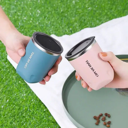 Two sleek 300ml stainless steel vacuum travel mugs in matte blue and pink with black lids and silver trim