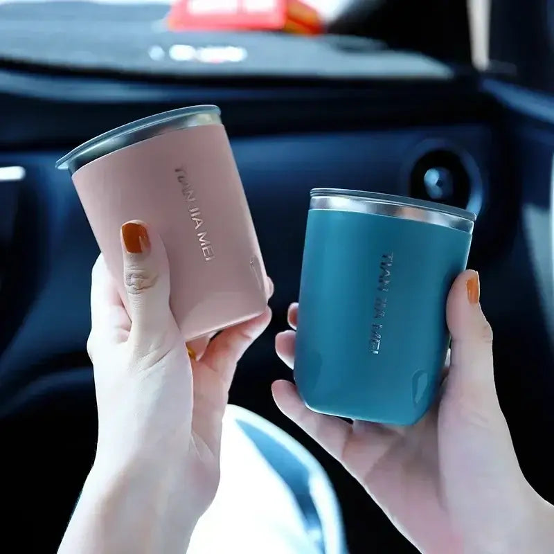 Two sleek 300ml stainless steel vacuum travel mugs in soft pink and teal with metallic lids and minimalist branding