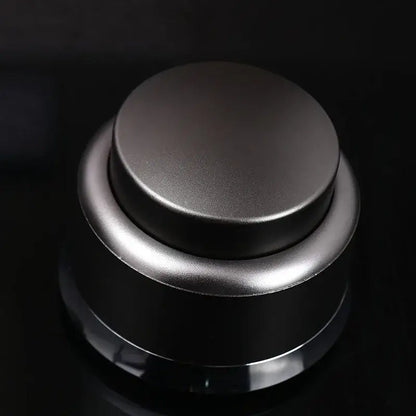 A sleek black and stainless steel decorbites adjustable coffee tamper with matte finish circular top and cylindrical base