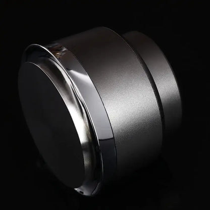 A sleek black and stainless steel decorbites adjustable coffee tamper with a brushed silver finish and polished chrome rim
