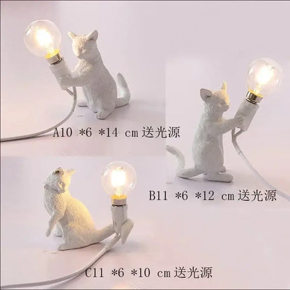 White ceramic cat resin table lamp with glowing bulb held in paws for bedroom decorbites cat resin decor