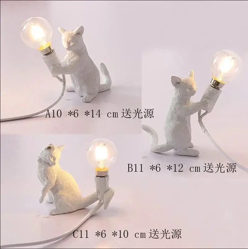 White ceramic cat resin table lamp with glowing bulb held in paws for bedroom decorbites cat resin decor