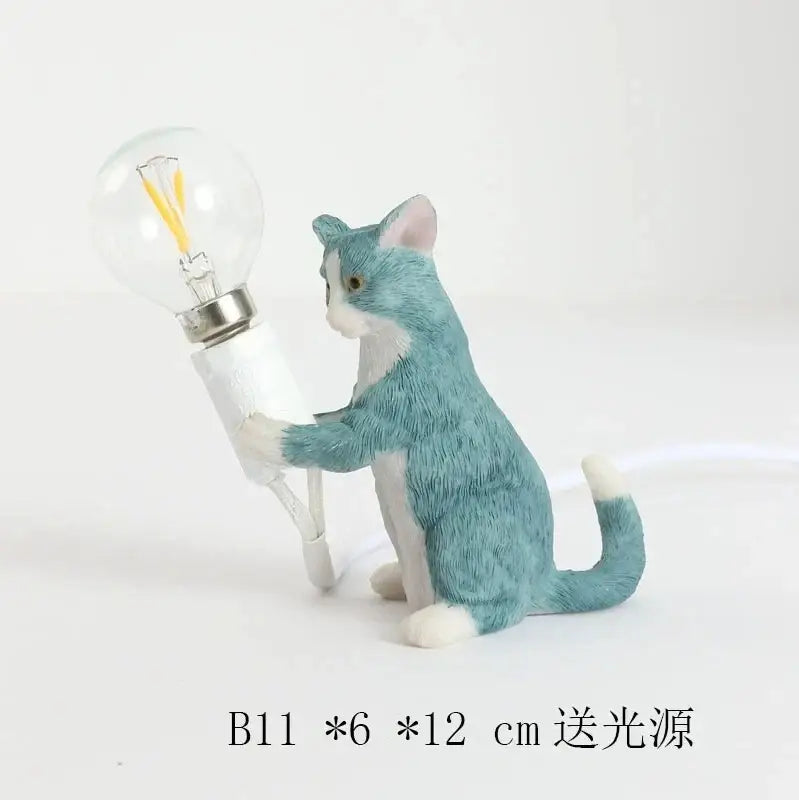 A teal and white ceramic cat resin table lamp holding a clear filament bulb for bedroom decorbites decor