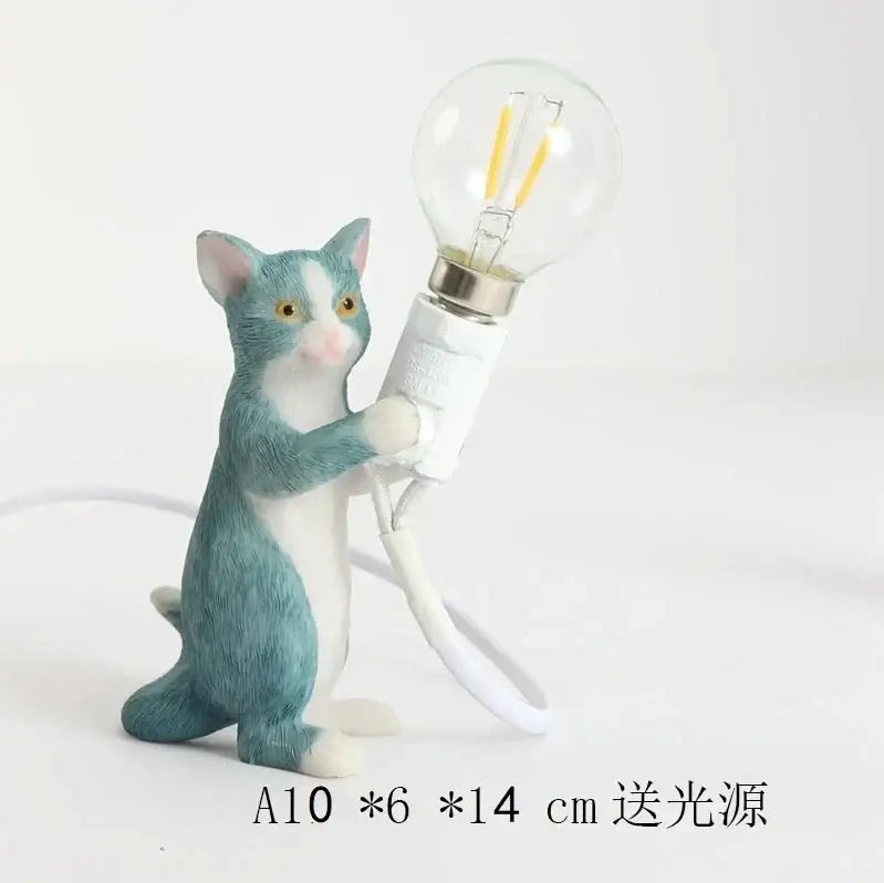 A teal and white ceramic cat resin table lamp holding a clear bulb designed as an adorable decorbites cat resin lamp