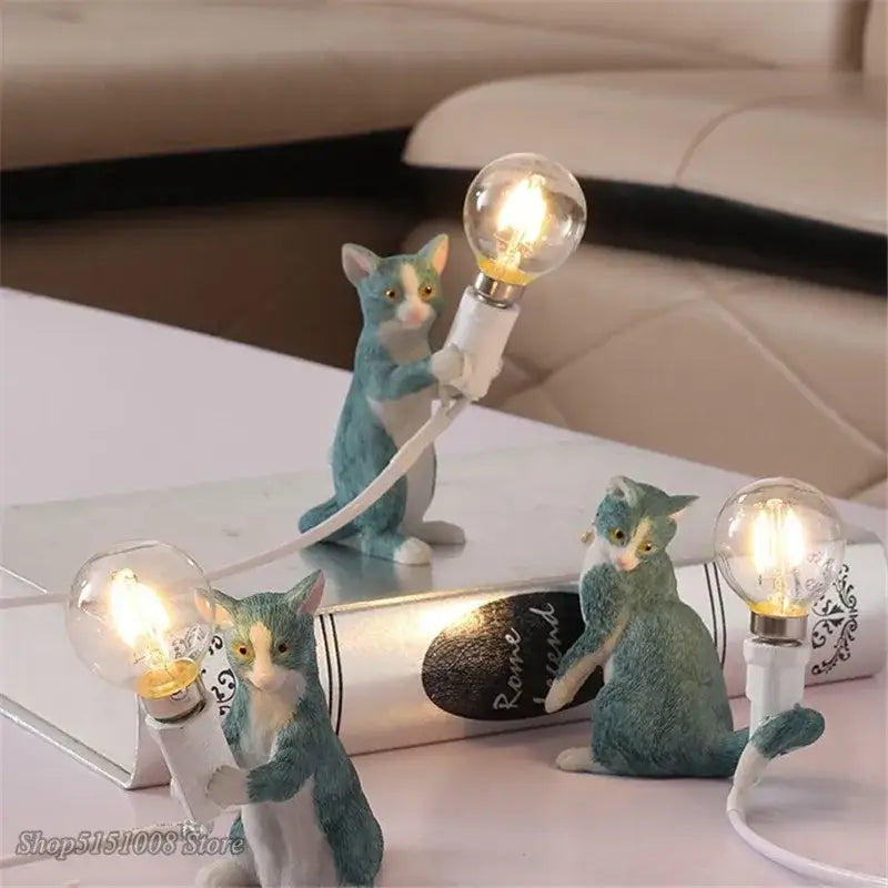 Three blue and white cat resin table lamps holding glowing bulbs for bedroom decorbites cat resin decor