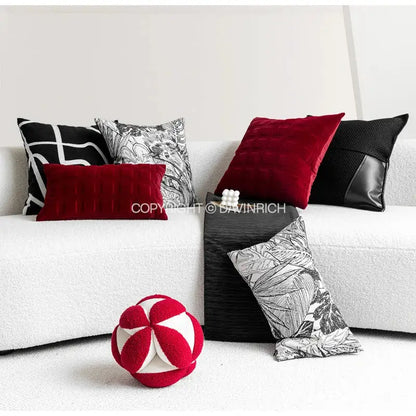 Red and white plush spherical toy complementing black and white jungle plant raccoon pillow cover decorbites decor
