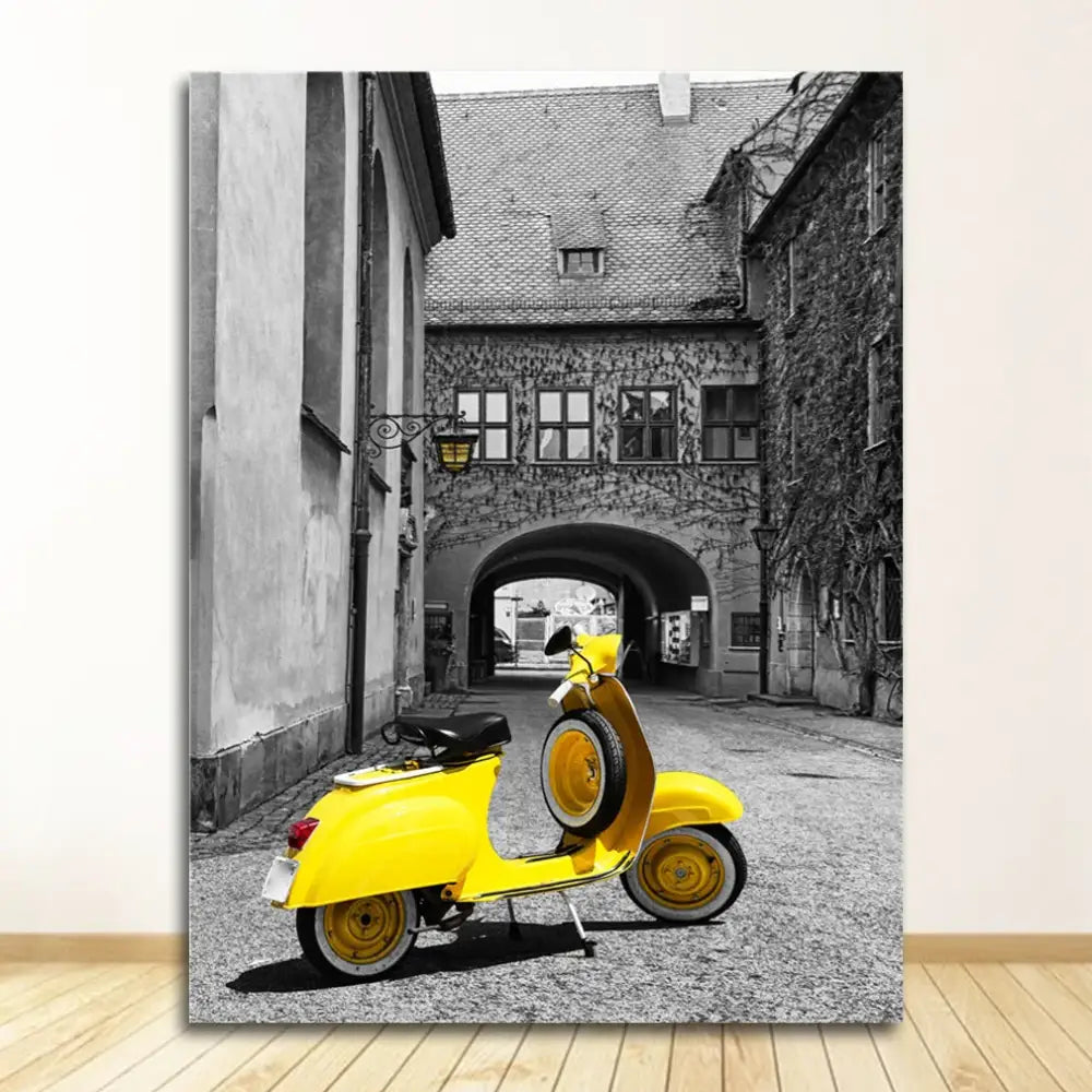 Bright yellow vespa scooter with black seat and wheels parked under arched doorway beside decorbites black and white nordic landscape canvas set