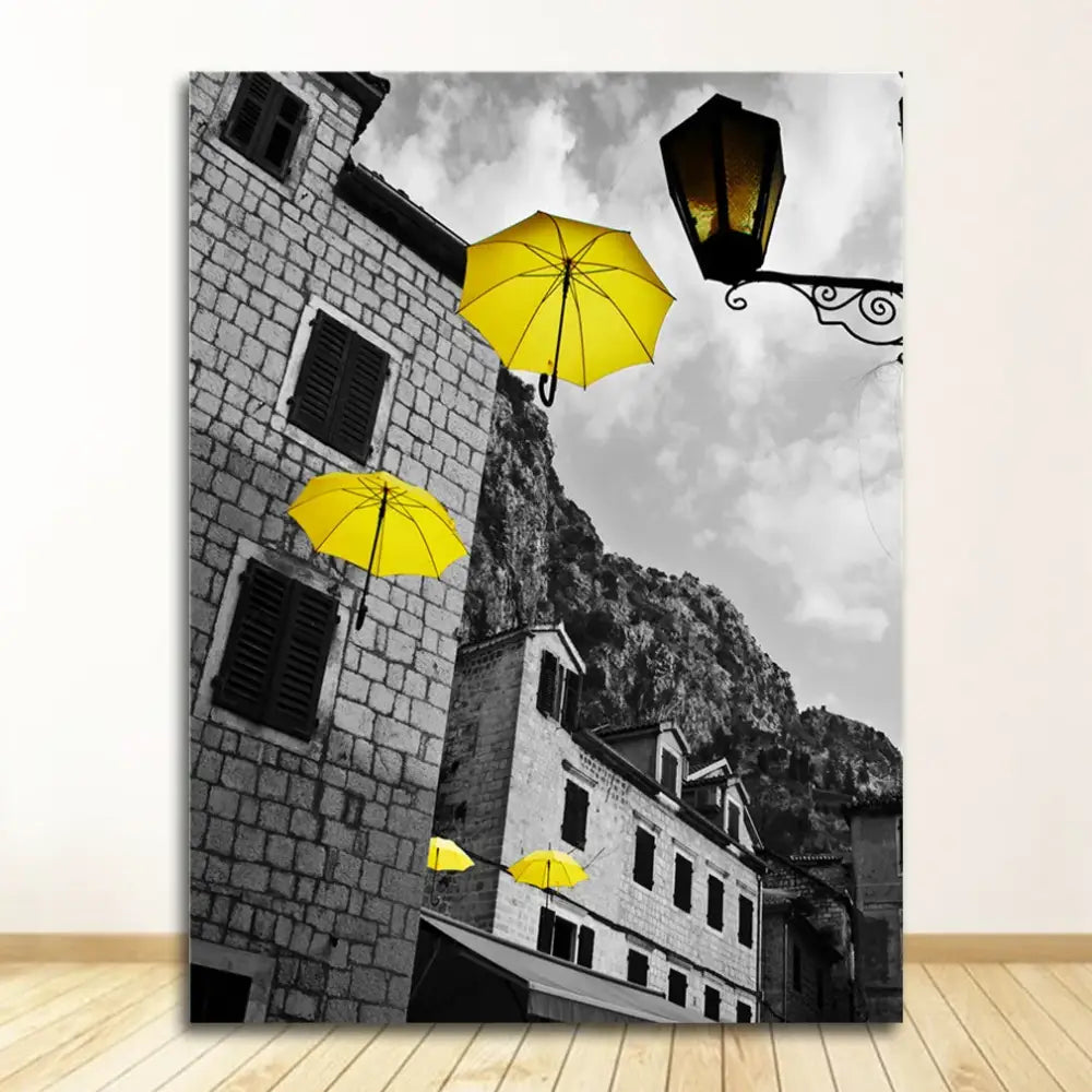 Decorbites™ black and white nordic landscape canvas set with vibrant yellow umbrellas against stone buildings backdrop