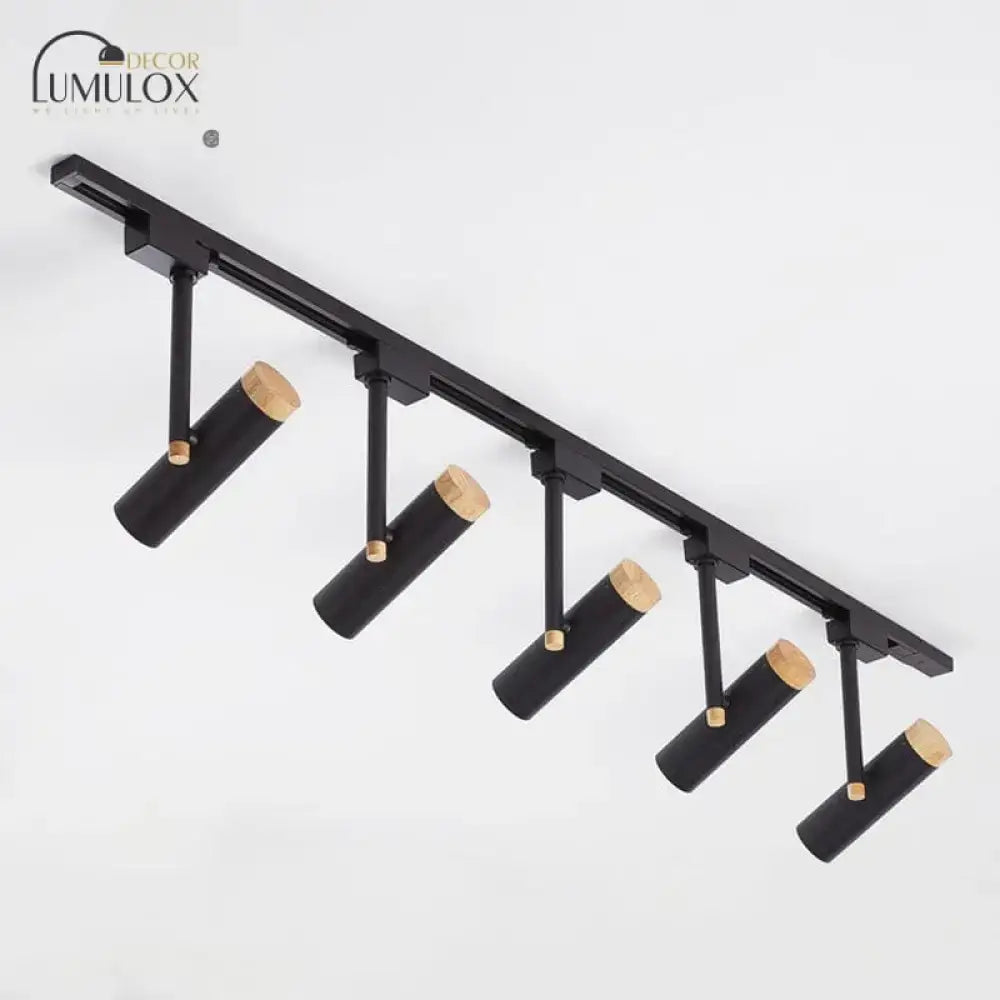 Black cylindrical track lighting fixtures with natural wood caps designed by lumulox for modern interior decor