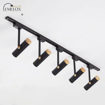 Black cylindrical track lighting fixtures with natural wood caps designed by lumulox for modern interior decor