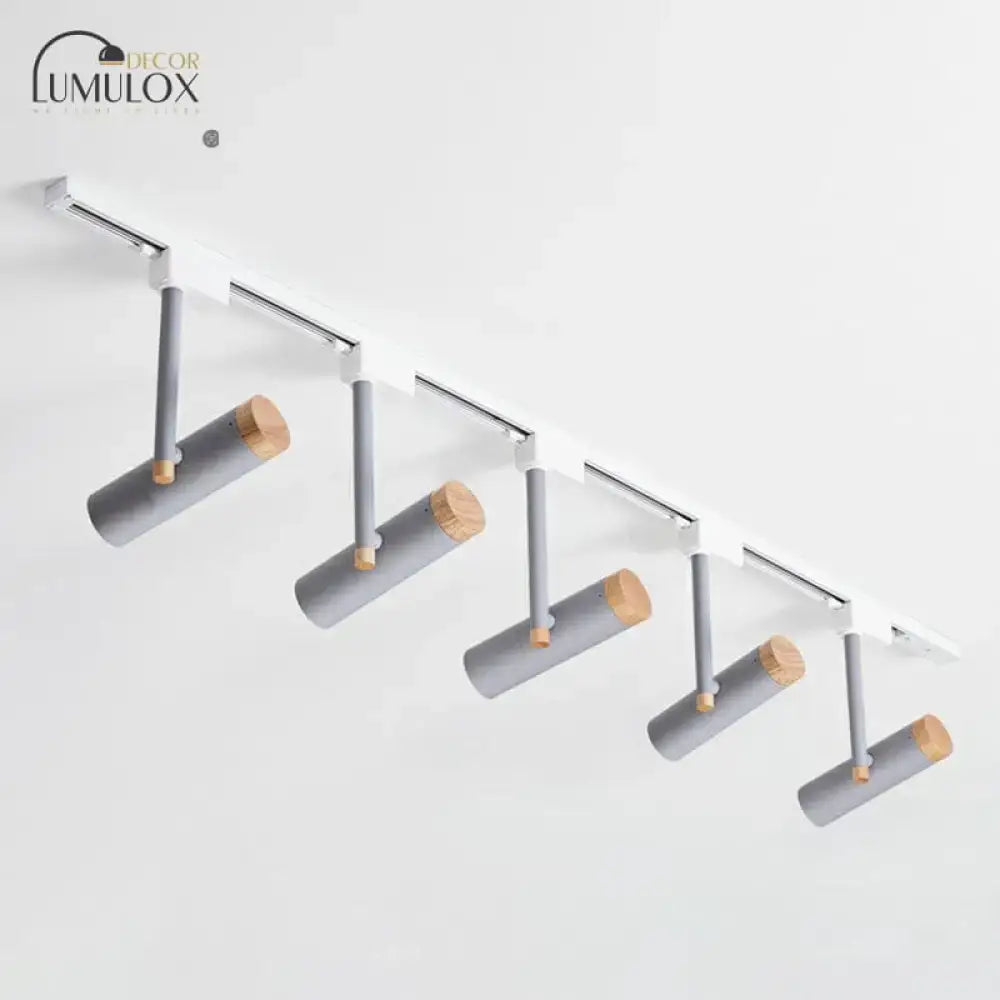 Modern track lighting system with five gray cylindrical heads featuring natural wood caps on a white rail by DecorBites™
