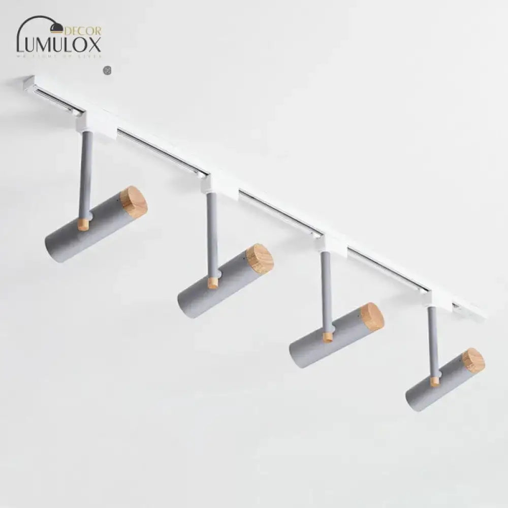 Modern DecorBites™ Nordic tubular metallic spotlight with four gray cylindrical fixtures and natural wood caps on white rail