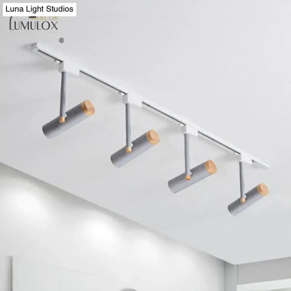 Modern track lighting system with four gray cylindrical fixtures featuring wood caps and metallic arms by DecorBites™