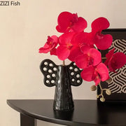 Black angel elephant ceramic vase with perforated wings holding vibrant artificial flowers for living room decorbites decor