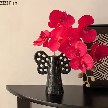 Black angel elephant ceramic vase with perforated wings holding vibrant artificial flowers for living room decorbites decor