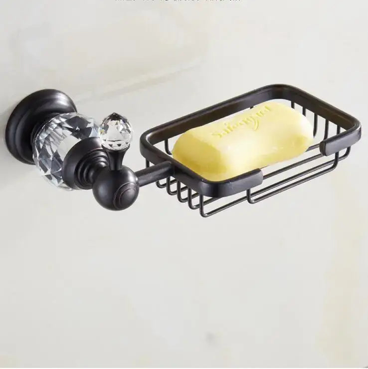 Black brass bathroom accessories set featuring a black metal soap dish with crystal accents holding a yellow soap bar
