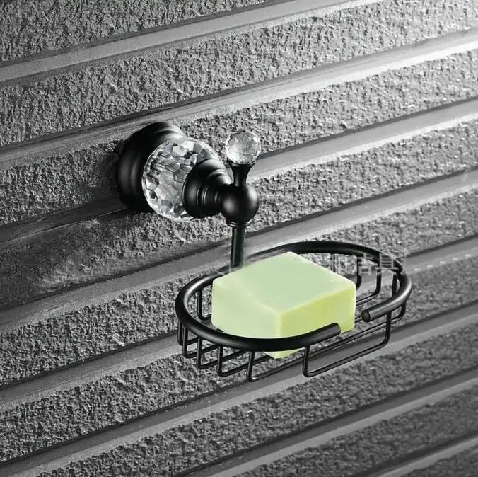 Black metal soap dish with crystal accents holding a green soap bar from black brass bathroom accessories set