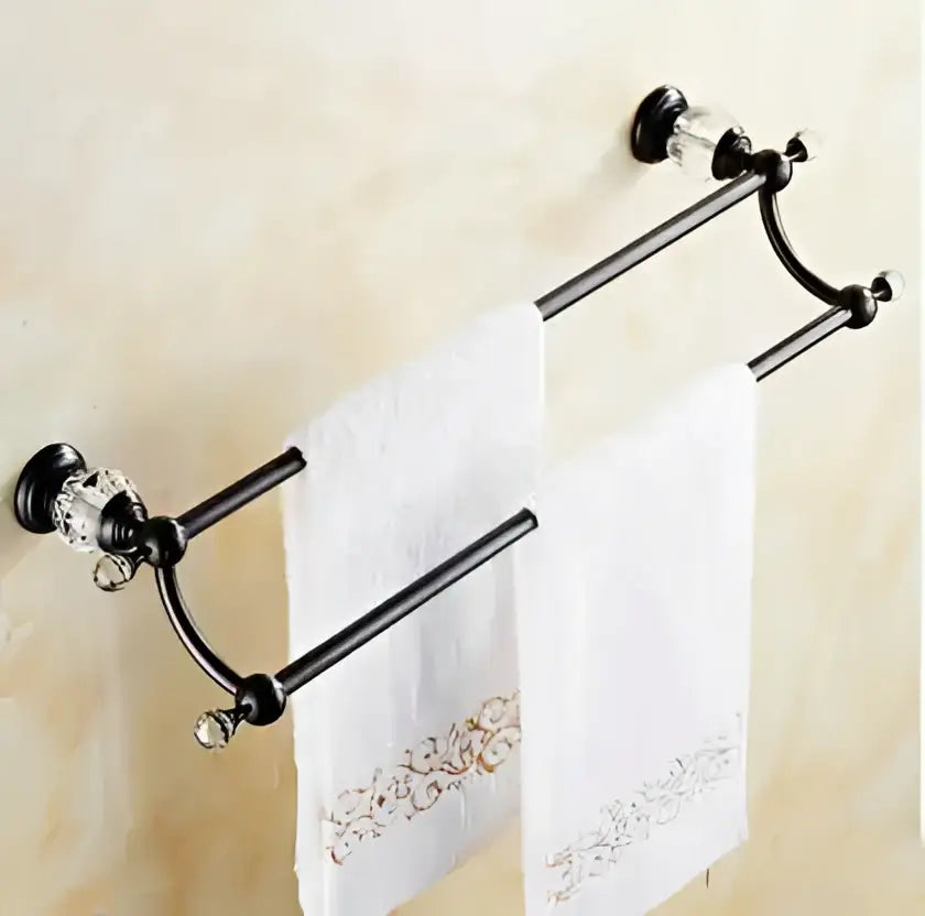 Black brass bathroom accessories set featuring a black metal towel rack with crystal accents holding white towels