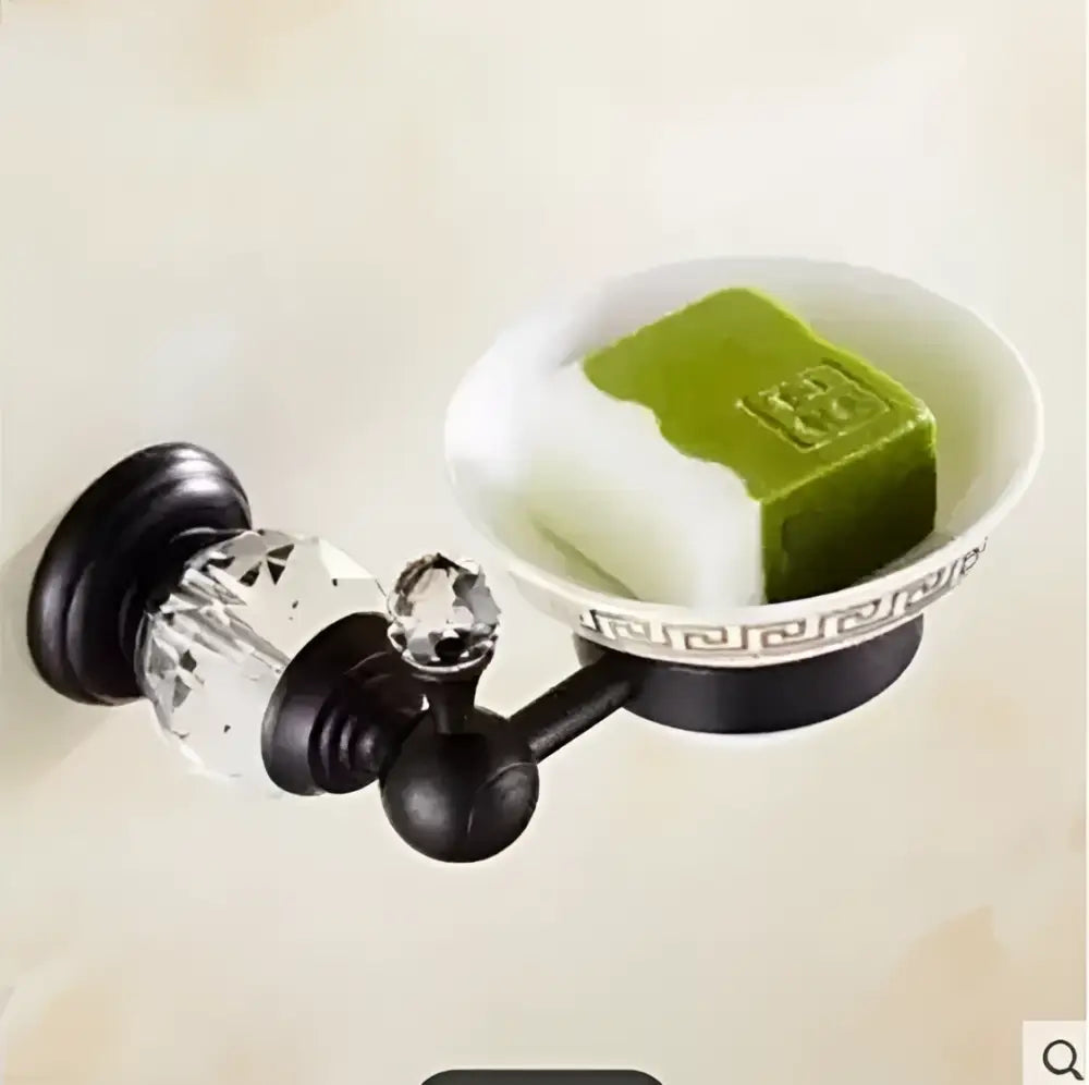 Black brass and crystal bathroom accessories set with a white Greek key pattern bowl holding green and white soap bars