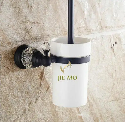 White ceramic toilet brush holder with black brass mounting bracket and crystal knob in bathroom accessories set
